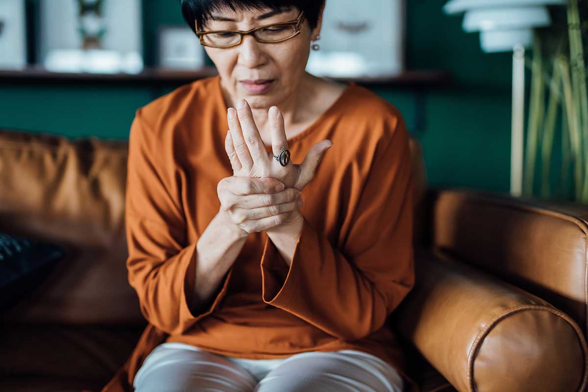Woman holding hand in pain, possible serious hand injury or fracture symptoms